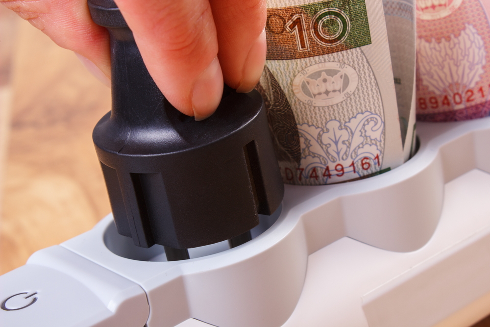 Woman unplugging appliance to save money