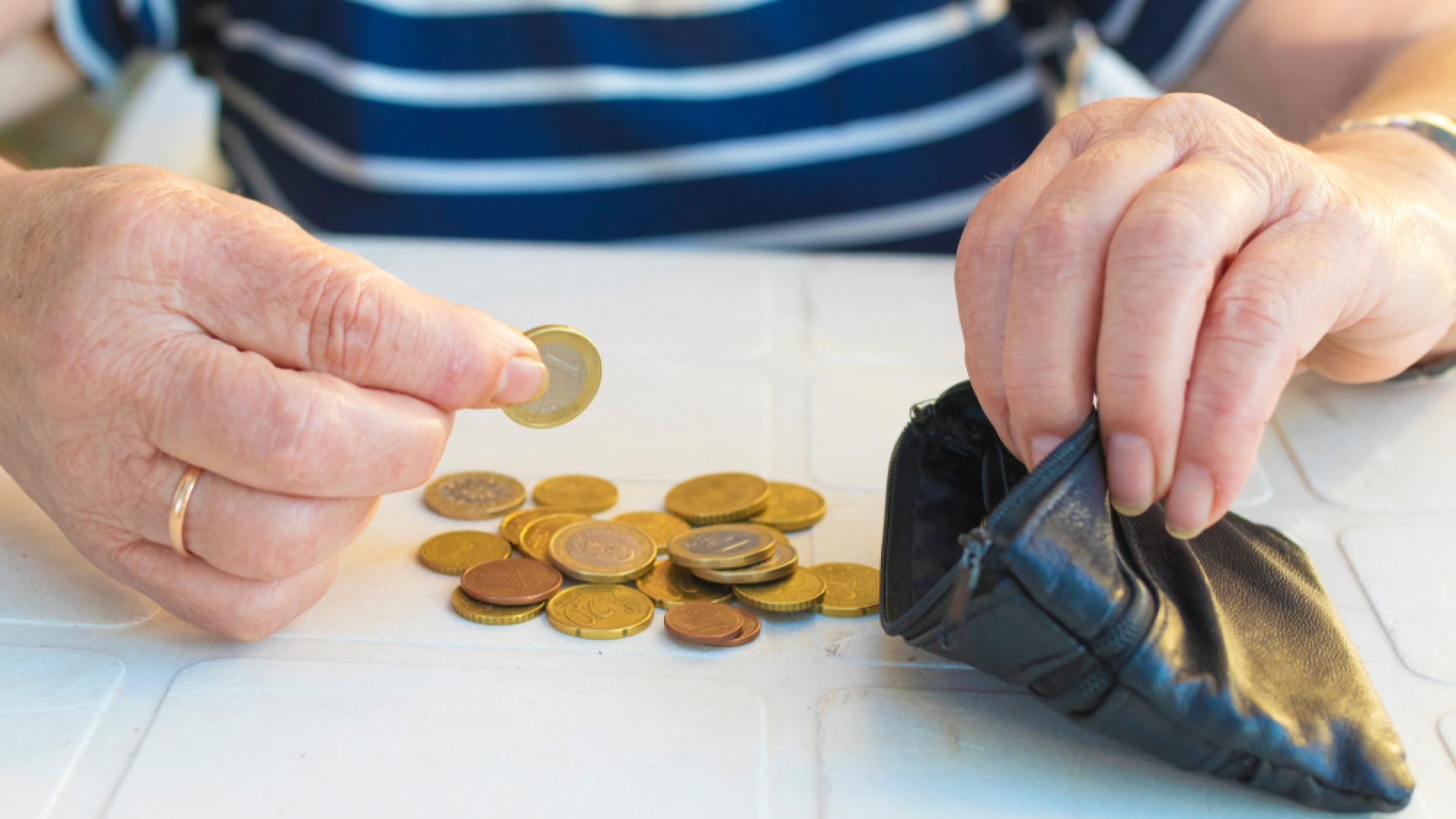 Hand,With,Coins,Saving,On,Wallet