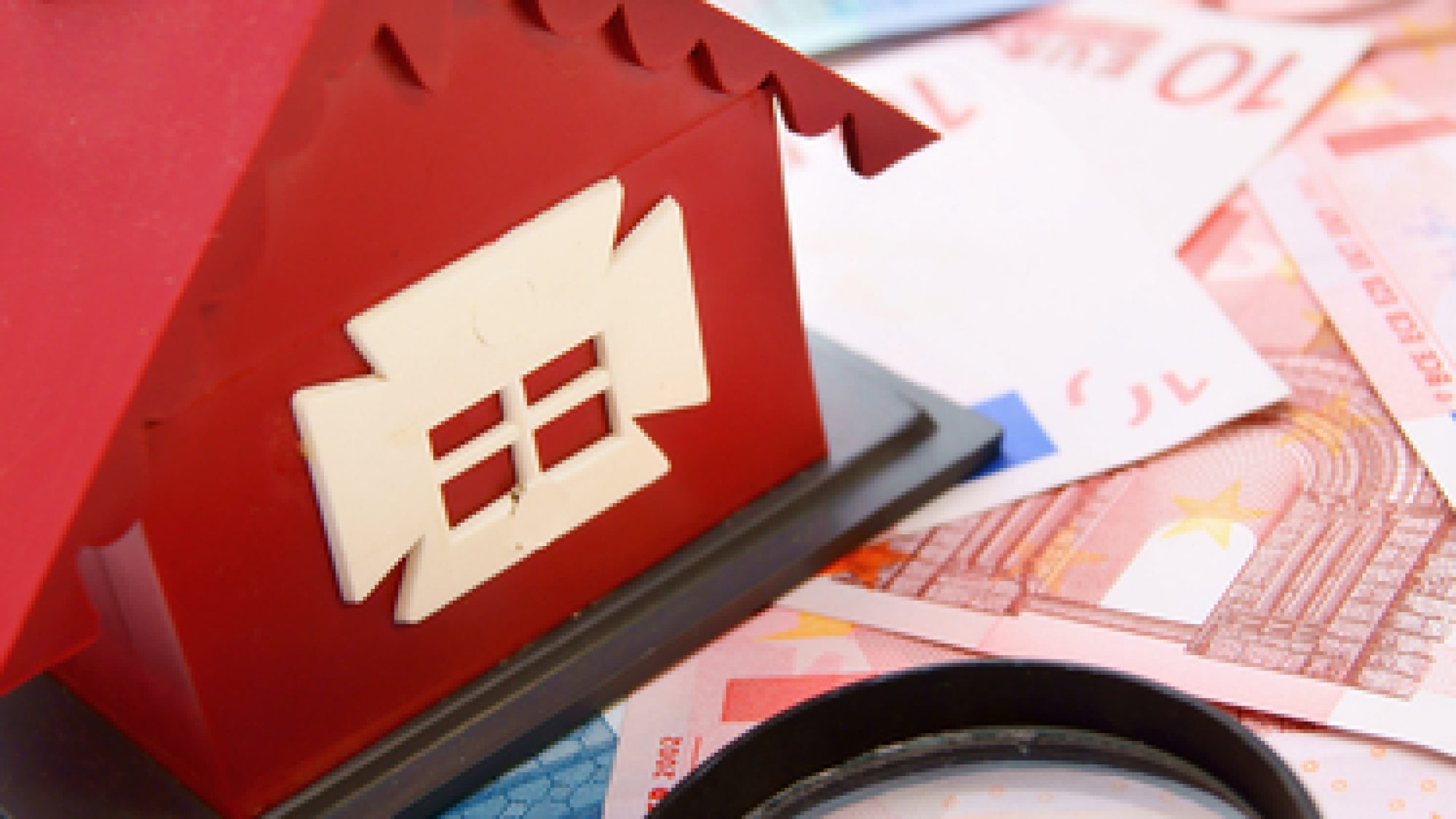 Toy,House,And,Magnifier,On,The,Money.