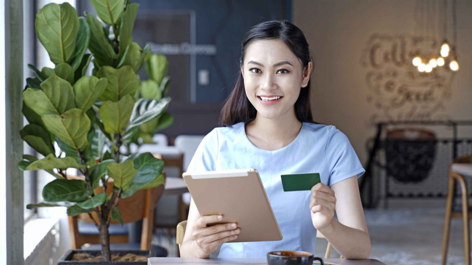 Asian,Pretty,Attractive,Woman,Sitting,In,Coffee,Shop,Using,Smart