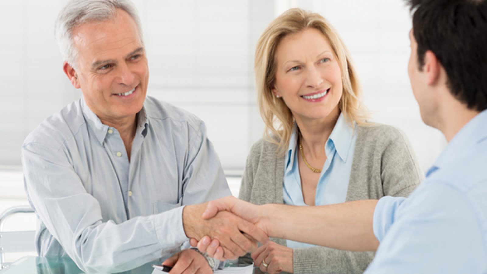 Senior,Happy,Couple,Shaking,Hand,With,Financial,Advisor