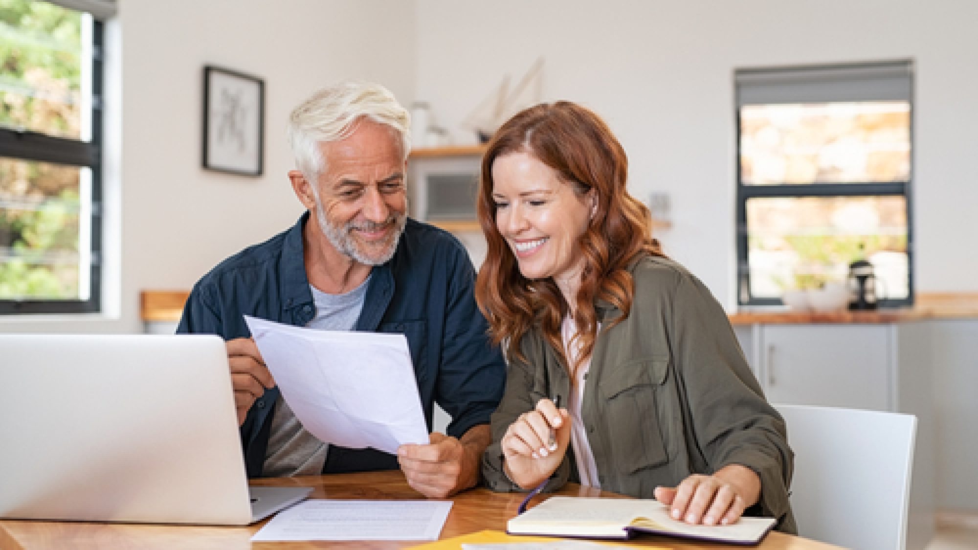 Mature,Smiling,Couple,Sitting,And,Managing,Expenses,At,Home.,Happy