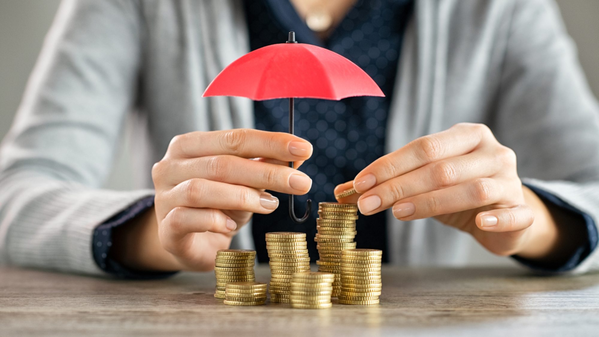 Young,Woman,Hands,Holding,Red,Umbrella,Over,Stacked,Coin,On