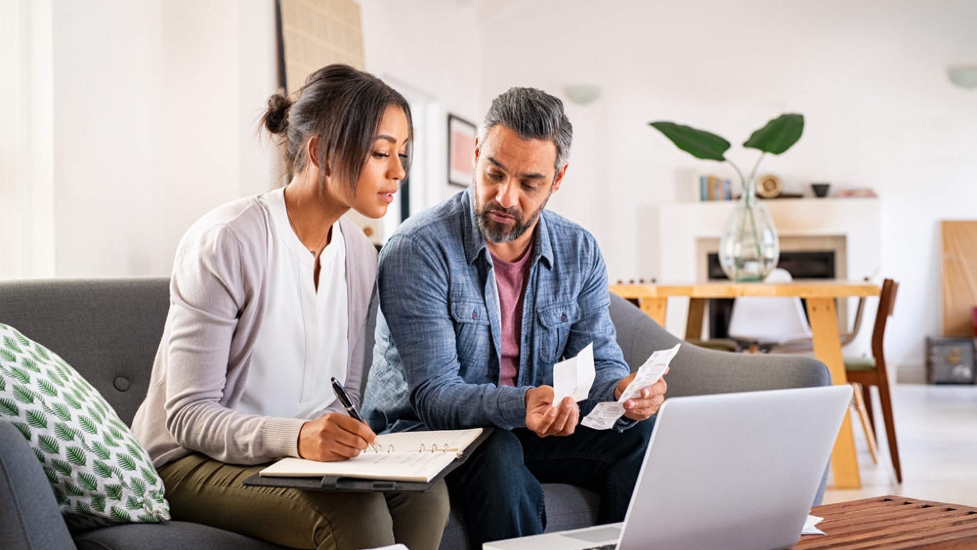 Mature,Couple,Calculating,Bills,At,Home,Using,Laptop.,Multiethnic,Couple