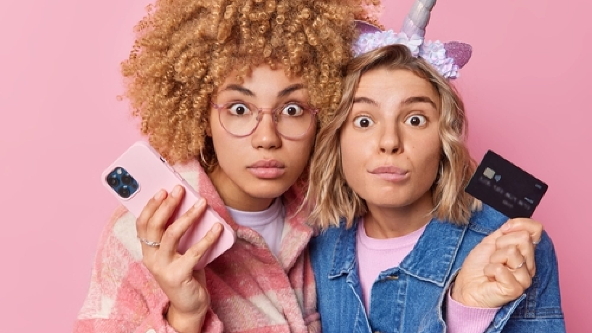 Emotional,Two,Women,Stare,Shocked,At,Camera,Hold,Mobile,Phone