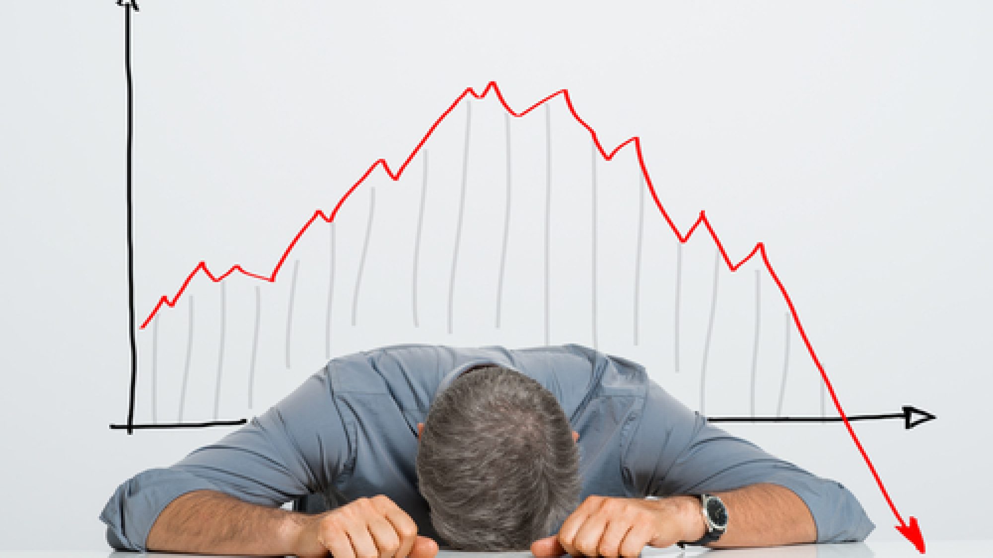 Depressed,Businessman,Leaning,His,Head,Below,A,Bad,Stock,Market