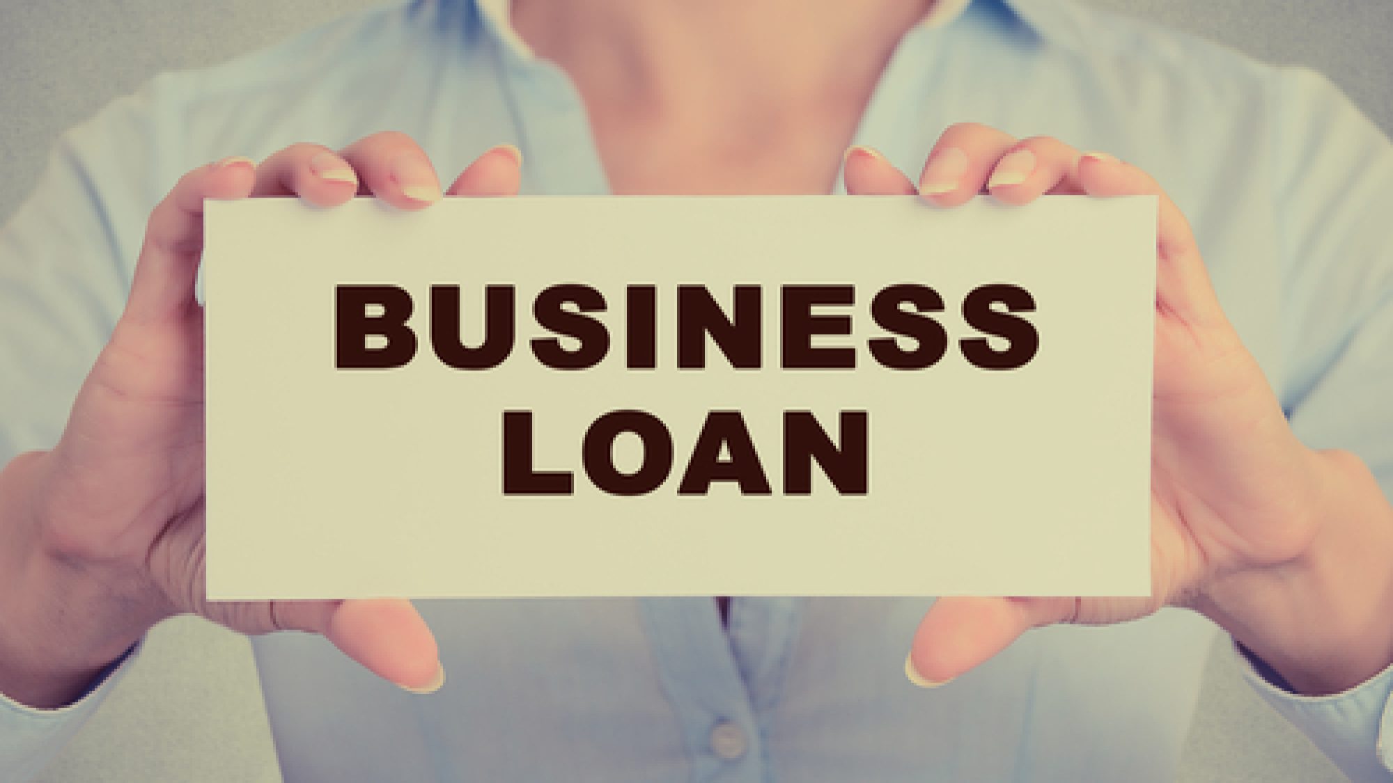 Business,Woman,Hands,Holding,White,Card,Sign,With,Business,Loan