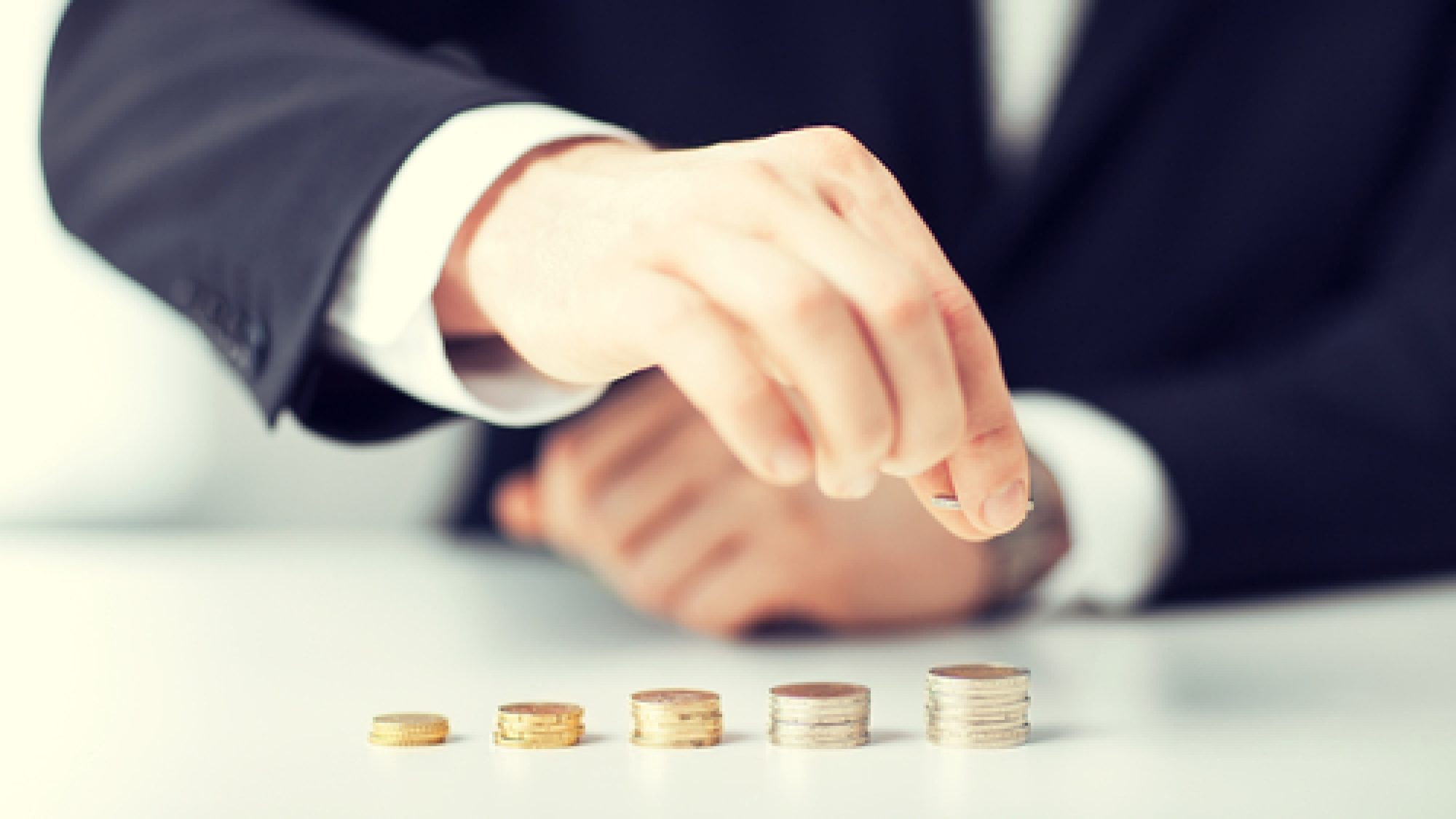 Picture,Of,Man,Putting,Stack,Of,Coins,Into,One,Row